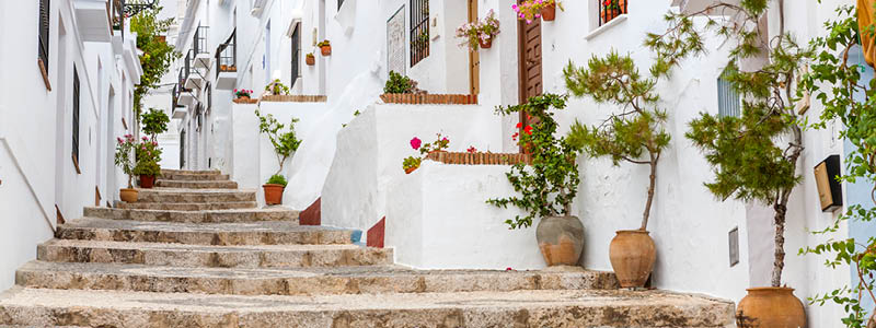 Trappa uppfr vita hus och blomkrukor i byn Frigliana, Andalusien.